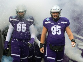 David Brown and Jimmy Hawley of the  Western Mustangs emerge from a pre-game smoke show before the 2018 Mitchell Bowl against Saskatchewan at London's TD Waterhouse stadium. Photograph taken on Saturday November 17, 2018.  Mike Hensen/The London Free Press