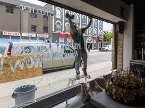 Dave Griffin of Provincial Glass and Mirror installs a new window at the Grace Restaurant at Clarence and Dundas streets in downtown London. The new pane of glass, replacing one broken May 16, costs about $1,500 and it's one of two that were broken last month. (Mike Hensen/The London Free Press)