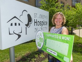 Janet Groen, executive director of St. Joseph's Hospice of London, holds up a big cheque from its monthly 50/50 draw. The hospice launched the lottery last year when it could not run its usual fundraisers because of restrictions in gatherings to slow the spread of COVID-19. (Mike Hensen/The London Free Press)