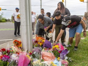 Rana Najjar, her son Rashad, 11, her husband and sister Hadin place flowers on June 7 at an impromptu memorial to a London Muslim family that was struck down one night earlier at the intersection of South Carriage and Hyde Park roads in London while walking. Four members of the family were killed and a fifth, a nine-year-old boy, suffered serious injuries in what police allege was an intentional act by a driver targeting Muslims. (Mike Hensen/The London Free Press)
