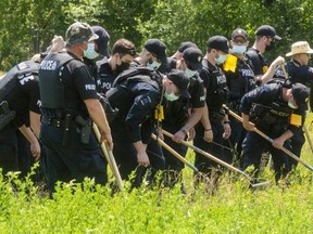 London police officers search for evidence in a grassy lot south of Nelson and Colborne streets. (Free Press file photo)