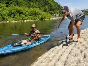 Mitchell Wright, 17, laughs as his grandfather Herb Kroger had a hard entry into his kayak below Springbank Dam. (Mike Hensen/The London Free Press)