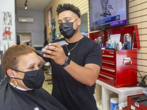Daniel Lopez, co-owner of Five Star Barber Shop on Wellington Street in London, says the phones have been ringing almost non-stop since Wednesday's Step 2 reopening. With customers like Jennifer Grant booking appointments into mid-July, he expects they'll be packed for weeks. (Mike Hensen/The London Free Press)