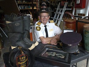 Former London fire chief Jim Fitzgerald wears his father's fire helmet, part of the collection of firefighting artifacts he amassed. Fitzgerald, who died June 15 at the age of 86, wanted to open a firefighting museum in London. (File photo)