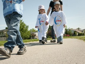 Kayla, 4, left, and Kailer, 5, right, hold hands as they walk around Ashley Oaks Public School while taking part in a mini Relay for Life in London on Friday June 3rd, 2011.  (Free Press file photo)