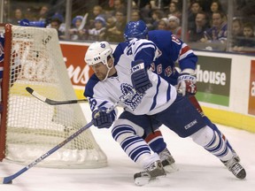 Nathan Perrott of the Toronto Maple Leafs circles in back of Mike Dunham and the New York Rangers net and beats Eric Lindros for control of the puck during first-period action of a game in 2003. (File photo).