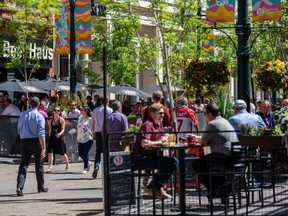 People spend the sunny lunch hour on the patios on Stephen Avenue in Calgary as restaurants reopen for outdoor dining on June 1, 2021.