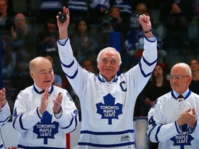 George Armstrong gestures to fans in Toronto during a night to celebrate Maple Leafs greats. He is flanked by Red Kelly and Dave Keon. (Getty Images file photo)