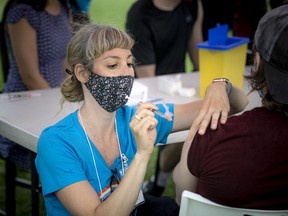 Registered nurse Vicki Meyouhas administers COVID-19 vaccine.