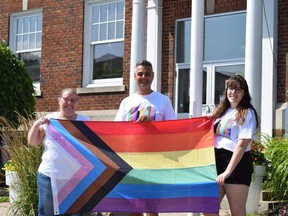 Strathroy Pride festival organizers Kelly Fleming, Frank Emanuele and Lauren Huston hold a rainbow pride flag outside Strathroy town hall, where it will be raised Saturday at 11 a.m. during the farmers' market.  (Calvi Leon/The London Free Press)