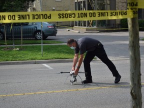 A forensic investigator prepares to fly a drone over the scene at 357 Dufferin Ave., where a London police officer shot a man after he charged at officers armed with two knives Tuesday night, police said. Photo taken Wednesday July 28, 2021. (CALVI LEON/The London Free Press)