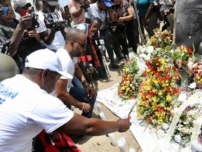 People pay their respects outside of the Presidential Palace in Port-au-Prince on July 14, 2021, in the wake of Haitian President Jovenel Moise's assassination that occurred early on July 7, 2021. - White House Press Secretary Jen Psaki said July 12, 2021 that the delegation of US law enforcement and national security officials who visited Haiti the previous day noted the country's instability in the wake of Moise's murder. She said Haiti's request for US troops to deploy and provide security was "still under analysis." Asked if the White House had ruled out sending troops, she said "no." No motive is publicly known for the killing, and questions are swirling about who masterminded the assassination. The delegation also met with Haitian political leaders, including interim Prime Minister Claude Joseph and Senate President Joseph Lambert, "to encourage open and constructive dialogue to reach a political accord that can enable the country to hold free and fair elections." (Photo by Valerie Baeriswyl / AFP) (Photo by VALERIE BAERISWYL/AFP via Getty Images)