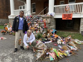 Geronimo Henry, left, who attended Brantford's Mohawk Institute residential school as a child, and Linda Parsons looked over the re-arranged memorial at the site. People have placed flowers, shoes moccasins and candles in memory of children who went to the school and those who have died in residential schools across Canada. It was vandalized this weekend, police say.