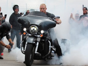 A man revs his motorcycle, creating a cloud of smoke, as a large crowd gathered outside London's provincial jail to mark the death of inmate Brandon Marchant, 32. Photo taken Saturday July 16, 2021 Dale Carruthers/The London Free Press