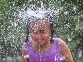 Naomi Somerville, 5, cools off at the splash pad at the Oakridge Optimist community park in London. "The water is nice and cold," she said. (Derek Ruttan/The London Free Press)