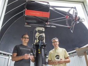 Western University scientists Denis Vida, left, and doctoral candidate Mike Mazur hold global meteor network cameras inside the Colibri Observatory in Granton, Ont. on Tuesday July 27, 2021.  Vida founded the global meteor network to pinpoint meteors more accurately. (Derek Ruttan/The London Free Press)