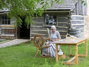 Fanshawe Pioneer Village historical interpreter Betty Rolfe uses a 160-year-old spinning wheel to transform wool into yarn outside of the 1865 Elgie Log House. The village is teaming up with other museums in London to run virtual programing on the civic holiday. (Derek Ruttan/The London Free Press)