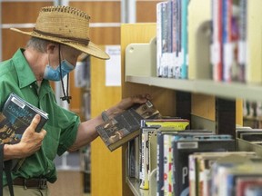 Steve Humphries picks up some summer reading at the Central Library in London. Photo take on Thursday July 8, 2021. (Mike Hensen/The London Free Press)