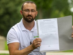 Jeremy Smith holds up his petition, circulating at marijuana retail stores, on Thursday, July 15, 2021. Smith is trying to get Londoners join in asking the province to allow a cannabis restaurant in London, Ont. (Mike Hensen/The London Free Press)