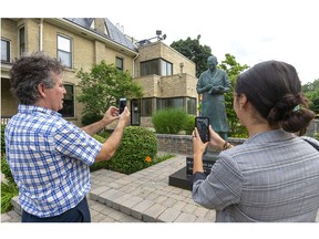 Banting House museum curator Grant Maltman demonstrates to reporter Calvi Leon how the app, made by EXAR studios, allows visitors to the National Historic site to see into the museum via augmented reality on their phones while the museum is shuttered due to COVID restrictions. (Mike Hensen/The London Free Press)