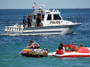 Floaters from the Canadian side pass in front of an OPP boat north of the Blue Water Bridge Sunday during the Port Huron Float Down. About 3,000 to 4,000 people were expected to take part. (Tyler Kula/The Observer)