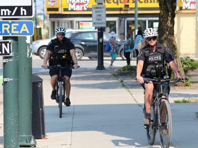Two London police officers cycle down Dundas Street. London police are consulting with the Ontario Association of Chiefs of Police on a possible COVID-19 vaccine mandate for police employees. Photo taken Aug. 20, 2021. DALE CARRUTHERS / THE LONDON FREE PRESS