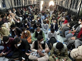 Afghan citizens board a Spanish military plane as part of their evacuation, at the Hamid Karzai International Airport in Kabul, Afghanistan, August 24, 2021.