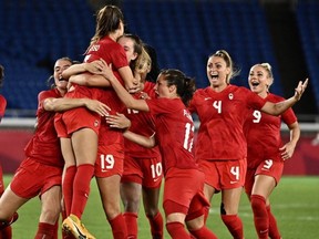 Canada's players celebrate after midfielder Julia Grosso (C) scored the winning penatly during the penalty shoot-out of the Tokyo 2020 Olympic Games women's final football match between Sweden and Canada at the International Stadium Yokohama in Yokohama on August 6, 2021.
