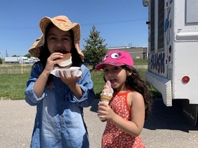 Fatima Abdullah, 7, and her five-year-old sister Inayah, right, enjoy some ice cream at MuslimFest at the Islamic Centre of Southwest Ontario Sunday Aug. 15, 2021.