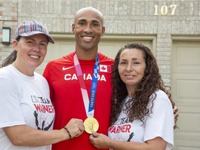 Olympic decathlon champion Damian Warner is flanked by his partner Jen Cotten, left, and mom Brenda Gillan at a celebration Tuesday night in London. Warner arrived in Canada on Monday and was reunited with his family, including his five-month-old son Theo. Warner said Theo's birth in March lifted his spirits during a difficult time training for the Tokyo 2020 Olympics. "It reset some things. Gave me some balance," he said. (Derek Ruttan/The London Free Press)