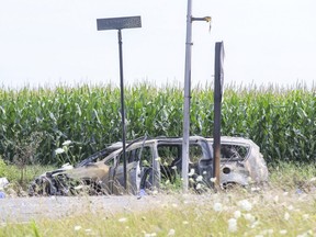 A burned-up husk of a vehicle and burned road signs at the intersection of Glanworth Drive and Wonderland Road show the severity of a crash Wednesday involving two vehicles. (Derek Ruttan/The London Free Press)