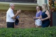 Conservative party candidate Rob Flack speaks with Dianne Springmann and her 13-year-old granddaughter Claudia Arthur while door-to-door campaigning in the London West riding on Monday. (Derek Ruttan/The London Free Press)