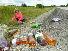 Cyclist Peggy Vandenberg sees plenty of garbage tossed by the side of the road in her rural neighbourhood in south London, such as these urine-filled bottles on Wilton Grove Road east of Veterans Memorial Parkway. Vanderberg collects garbage she sees on her frequent rides through the southeastern outskirts of the city and takes it to a nearby disposal facility. Photo taken  Aug. 3, 2021. (Mike Hensen/The London Free Press)