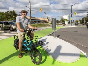 Jamieson Roberts, chair of the city's cycling advisory committee, pauses Tuesday at London's first intersection that uses a concrete island to protect direct a motorist turning right away from cyclists, skateboarders, wheelchair users or scooters. (Mike Hensen/The London Free Press)