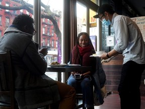 A server brings food to a table in a restaurant during the COVID-19 pandemic in the Manhattan borough of New York City, Dec. 11, 2020.