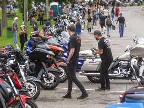 Two men check out motorcycles parked on a side street of Port Dover on Friday Aug. 13, 2021. Though Norfolk County declared the Friday the 13th rally a "non-event" to discourage attendance because of the COVID-19 pandemic, police estimate 30,000 to 35,000 people attended the rally, down from pre-COVID gatherings. Bikes were parked on side streets and lots, giving pedestrians more room to walk and physically distance. Mike Hensen/The London Free Press