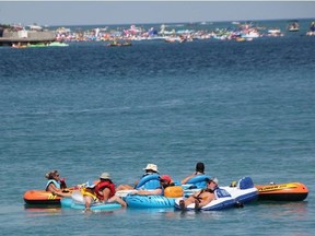 Floaters from the Canadian side of the border make their way down the St. Clair River in the 2019 Port Huron Float Down as U.S. floaters in the distance get ready to cast off from the lighthouse in Port Huron. The annual unsanctioned event takes place Sunday. (Observer file photo)