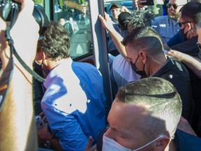 Rocks strike Prime Minister Justin Trudeau in the back as he boards his bus at the end of a campaign stop at the  London Co-Operative Brewing Company during the 2021 federal election campaign. (Derek Ruttan/The London Free Press)