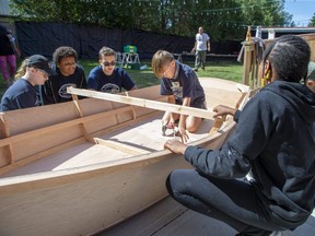 Tyler Groat, 11, attaches a keel to a rowboat Friday during a youth ship building project at the Periscope Playhouse in Port Burwell. The week-long exercise, run by a community organization called Stem2Stern, introduces grade 5-8 students to woodworking skills by crafting boats. (Derek Ruttan/The London Free Press)