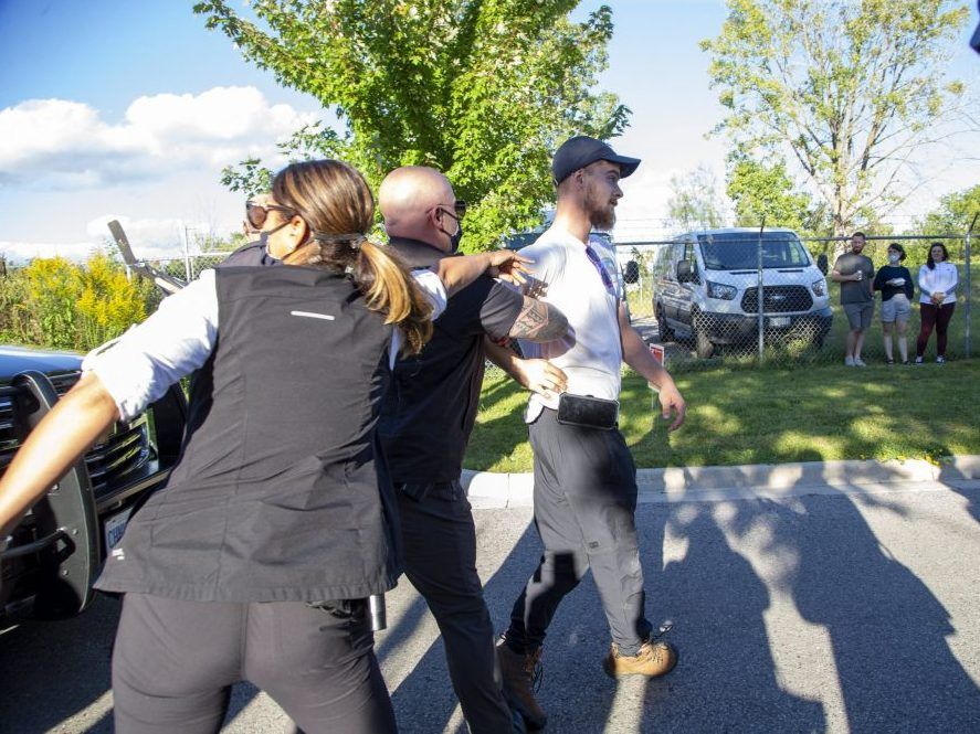 Mounties remove Shane Marshall after stones were thrown at Liberal Leader Justin Trudeau during a Sept. 6, 2021, campaign stop in London. (Derek Ruttan/The London Free Press)
