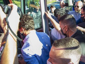 Rocks strike Liberal Leader Justin Trudeau in the back and head as he boards a bus at the end of a campaign stop at the London Brewing Co-op in London on Sept. 6, 2021. Derek Ruttan/The London Free Press