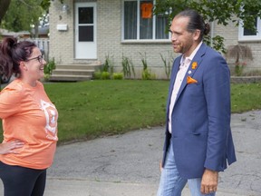 Jason Henry, New Democratic Party candidate in Lambton-Kent-Middlesex, speaks with Julie MacFarlane while campaigning door-to-door in Strathroy, Ont. on Wednesday September 8, 2021. (Derek Ruttan/The London Free Press)