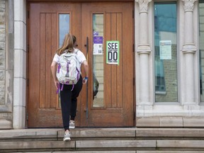 A student enters the Medway-Sydenham Hall residence at Western University in London. (Derek Ruttan/The London Free Press)