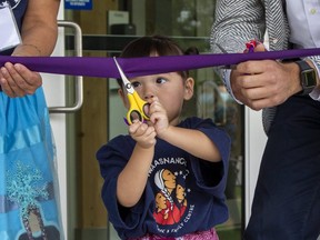 Two-year-old Luminous Baldwin cuts a ribbon during an opening ceremony at the Nshwaasnangong Child Care and Family Care Centre on Hill Street  in London on Thursday September 16, 2021. Assisting Luminous were her mother Brooke Chrisjohn and Ontario Minister of Education Stephen Lecce. The Southwest Ontario Aboriginal Health Access Centre says the "centre will focus on nurturing the spark of all indigenous children." Derek Ruttan/The London Free Press/Postmedia Network