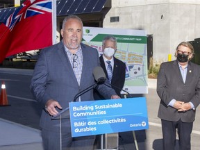 Ontario Minister of Energy Todd Smith makes an announcement in the West 5 neighbourhood of London. With him are Mayor Ed Holder (right) and Richard Sifton, president and CEO of Sifton Properties. (Derek Ruttan/The London Free Press)