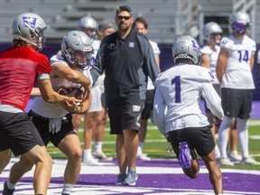 Western University's offensive coordinator Gaetan Richard watches as Jerome Rancourt fakes a handoff to running back Troy Thompson during a walkthrough on their new field at TD Stadium in London. Photograph taken on Thursday September 2, 2021. 
 Mike Hensen/The London Free Press