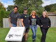 Beekeeper Dan Heffernan, left, Bzz Box founder Jonny Sikkema, Neat Cannabis brand director Leeana Newton and assistant store manager show off the beehive near Neat's new Komoka store. (Calvi Leon/The London Free Press)