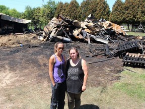 Lauren Edward, left, founder of Charlotte's Freedom Farm, and Christine Rettig, a former staffer who rescued several animals, stand in front of a barn destroyed in a fire at the Brook Line facility near Chatham on July 1, 2020. Rettig was charged by Chatham-Kent police with two counts of arson in that fire and a second at the animal sanctuary on June 20. (Ellwood Shreve/Chatham Daily News)