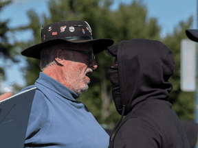 A protester of COVID-19 vaccine mandates, left, and a counter-protest yell at each other in Calgary. "As the percentage of people who are unvaccinated diminished, I think the tension increased rather than decreased."