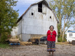 Gina McGahey, director of language and culture for the Chippewas Anishinaabe’aadziwin (Our way of life) department, stands in front of a barn that is the only building left from the Mount Elgin Industrial Institute residential school that operated from 1850 until 1967. Photograph taken Oct. 7, 2021. (Derek Ruttan/The London Free Press)